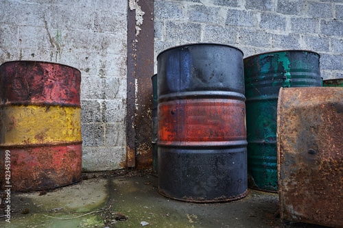Old chemical barrels. Blue, green red and rusty oil drum. Steel oil tank. Toxic waste warehouse. Hazard chemical barrel