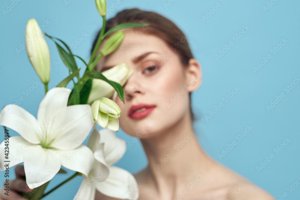 charming woman with white flowers on blue background portrait cropped view