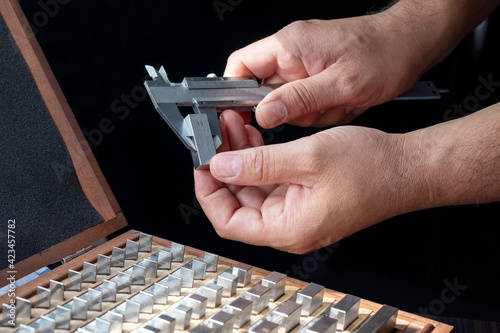 Worker is calibrating to vernier caliper with gauge block. Gauge blocks (also known as gage blocks, Johansson gauges, slip gauges, or Jo blocks) are a system for producing precision lengths.