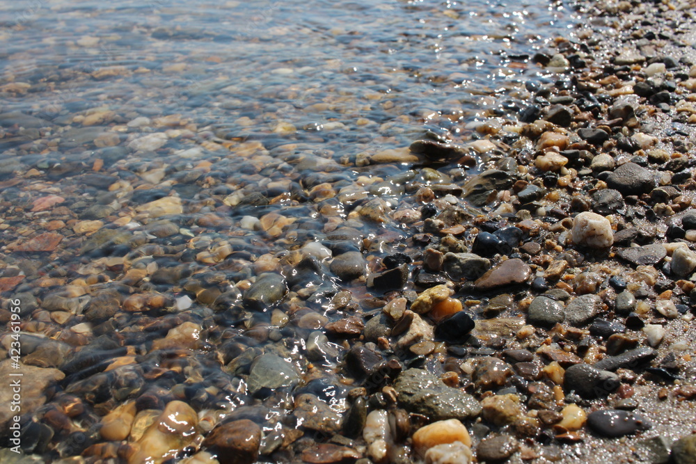 colorful stones on the beach on a rocky beach in the ocean waves