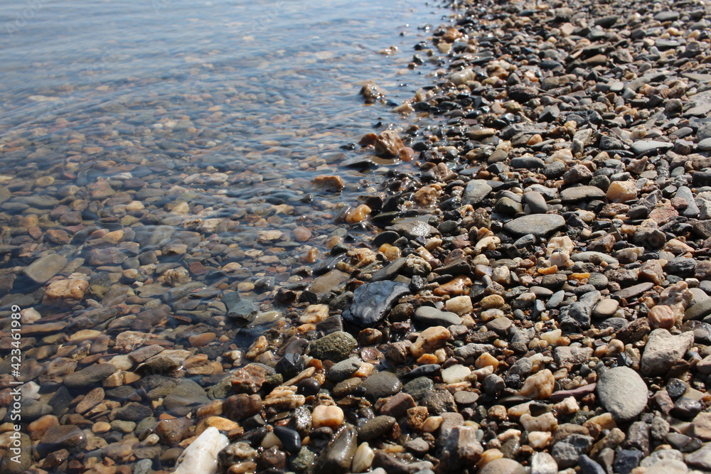 colorful stones on the beach on a rocky beach in the ocean waves colorful stones on the beach on a rocky beach in the ocean waves