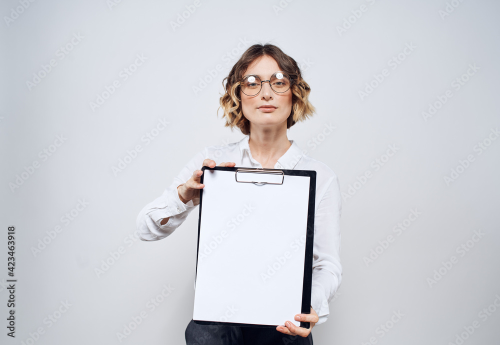 Business woman with a folder of documents in her hands and a white sheet of paper mockup Business woman with a folder of documents in her hands and a white sheet of paper mockup