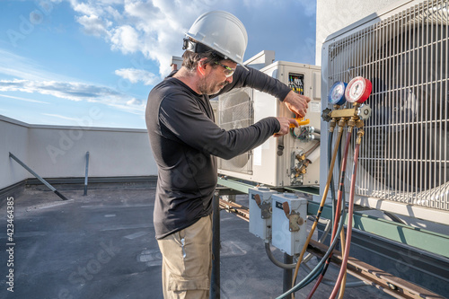 HVAC technician hooking up amp clamp photo