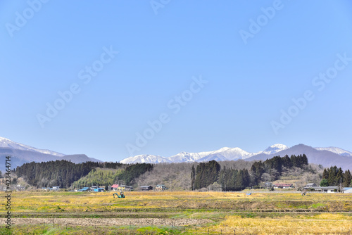 宮城の田園、春を待つ里山から雪の蔵王を望む