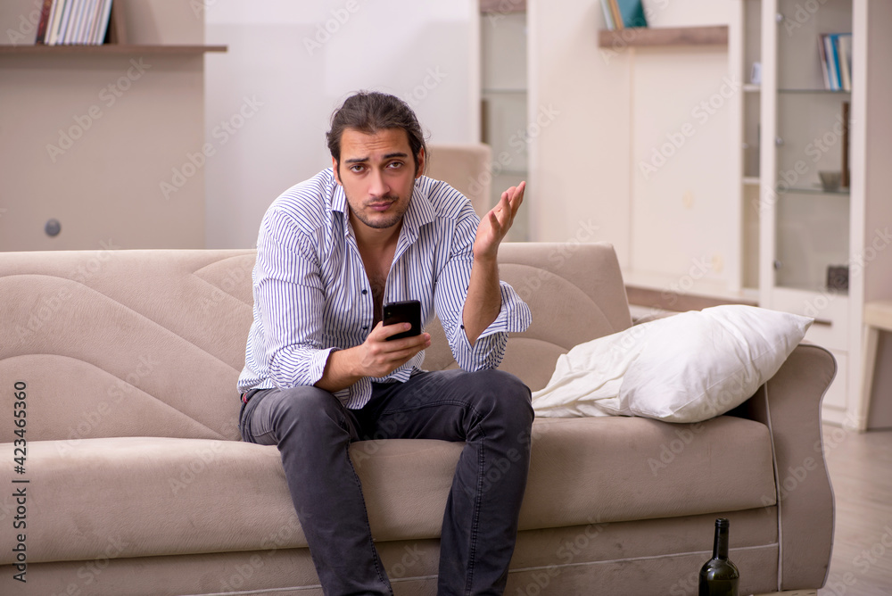 Obraz premium Young drunk man suffering at home