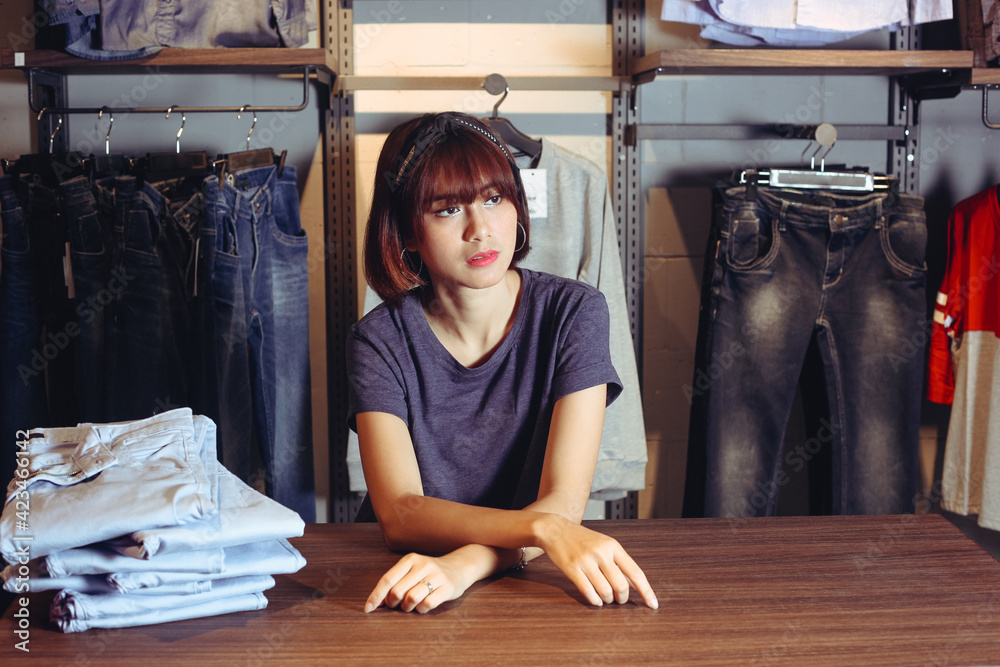 Beautiful asian woman sitting inside the clothing store