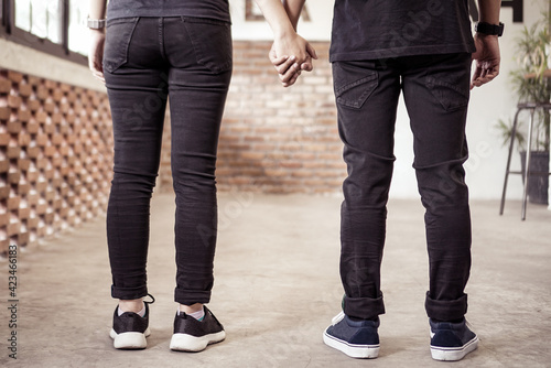 Back view of romantic young couple holding hand 