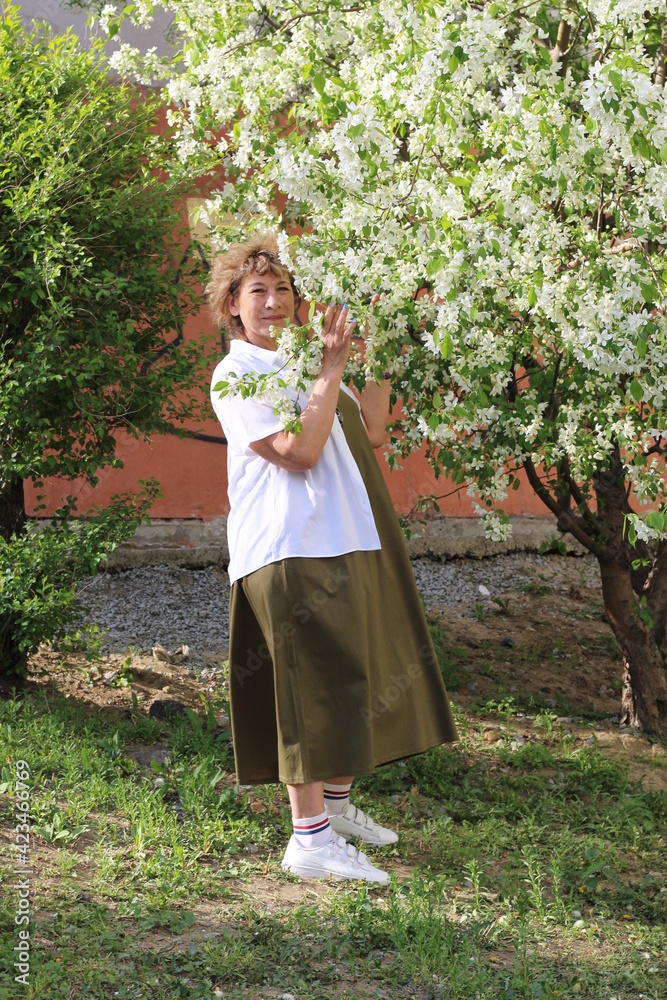Woman walking in the park in spring. Photoshoot in bloom.