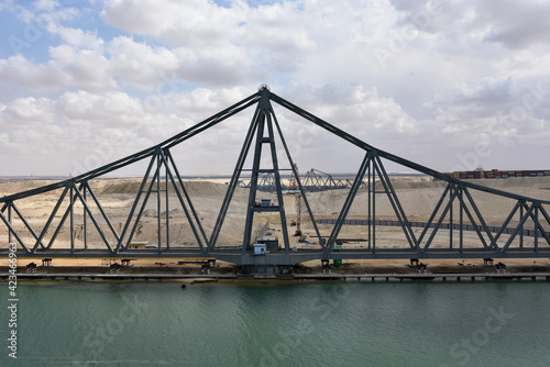 Landscape of Suez Canal, view from transiting cargo ship. Bridge construction on the Canal bank. 