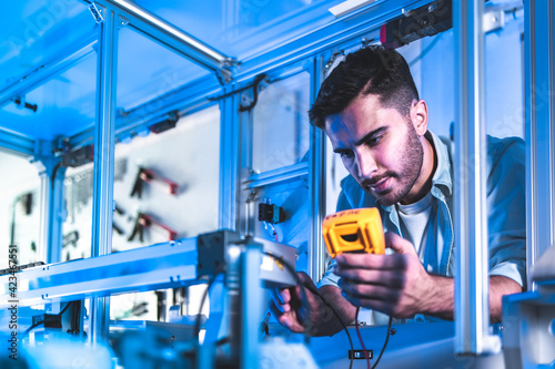 Male Engineers Maintenance Robot Arm at Lab. he are in a High Tech Research Laboratory with Modern Equipment. Technology and Innovation Concept.Professional.