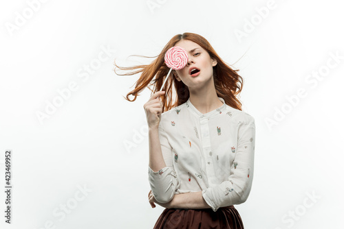 pretty red-haired woman with lollipop in hands emotions cropped view studio