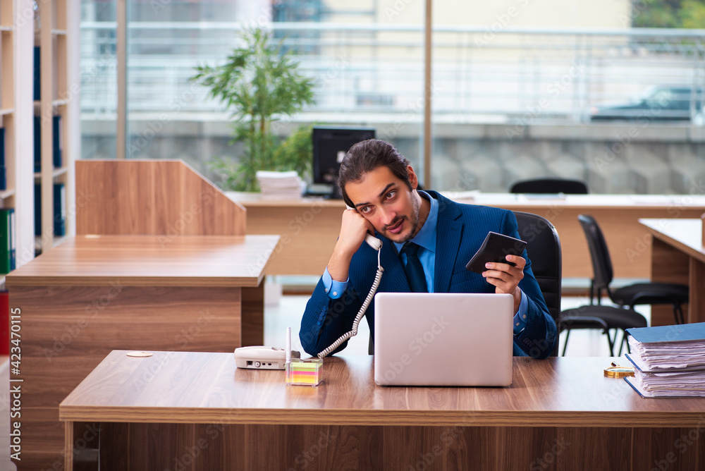 Young male bookkeeper working in the office Young male bookkeeper working in the office