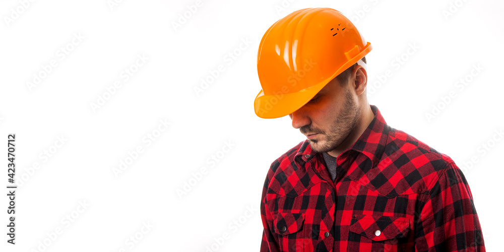 A man in a plaid shirt and a construction helmet on a white background. Concept Labor Day. A man in a plaid shirt and a construction helmet on a white background. Concept Labor Day.