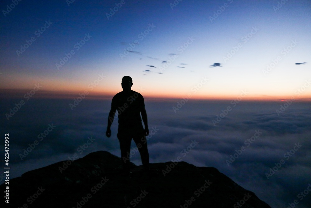 silhouette of man standing on top of mountain silhouette of man standing on top of mountain
