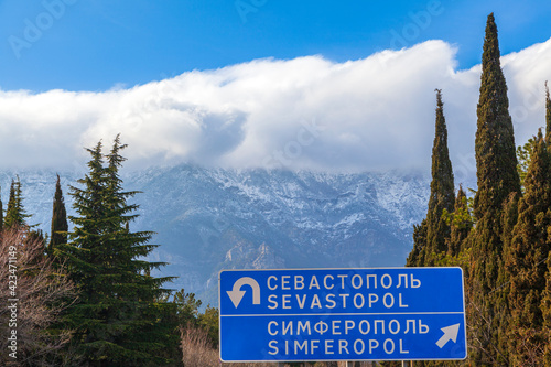 Coast of the Crimea peninsula, rocky mountains, aerial view of the sea resort of Yalta. Road sign Sevastopol-Simferopol
