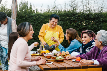 latin grandmother and granddaughter, daughter cooking mexican food at home, three generations of women in Mexico
