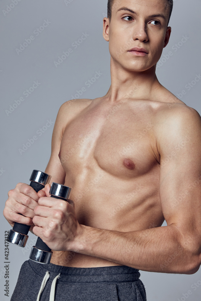 handsome guy athletic physique dumbbells in the hands of a workout muscle handsome guy athletic physique dumbbells in the hands of a workout muscle