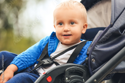 Cute funny baby in stroller outdoors