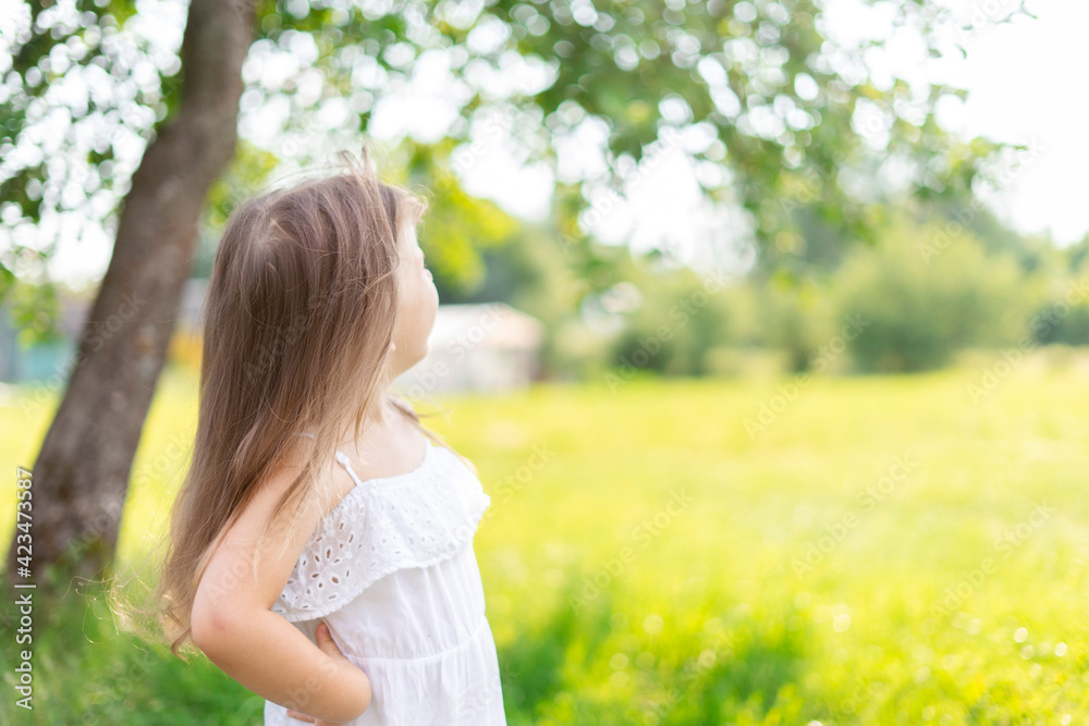 kid girl with long hair in a white dress rejoices in the sun on a summer day, copy spase kid girl with long hair in a white dress rejoices in the sun on a summer day, copy spase