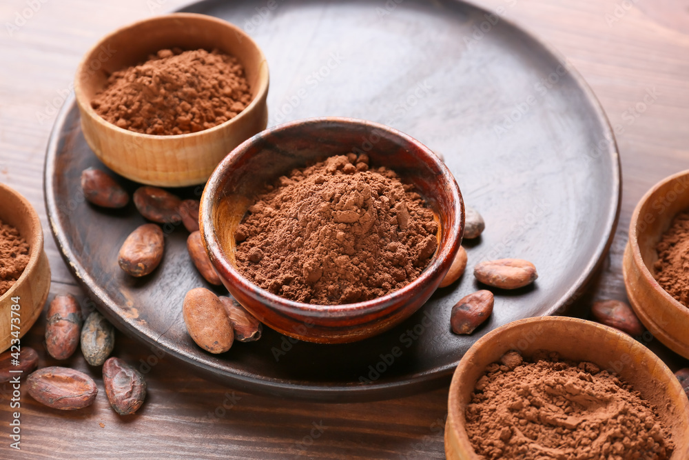 Bowls with cacao powder and beans on wooden background Bowls with cacao powder and beans on wooden background