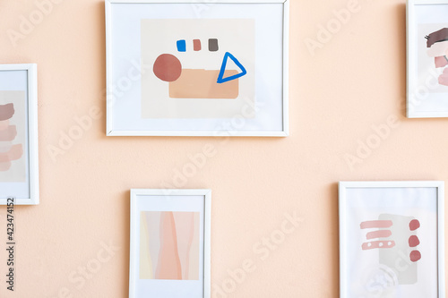 Beautiful pictures hanging on color wall, closeup