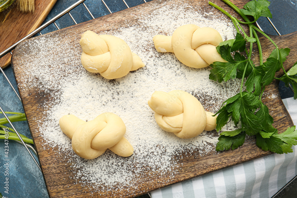 Board with uncooked garlic buns on color background Board with uncooked garlic buns on color background