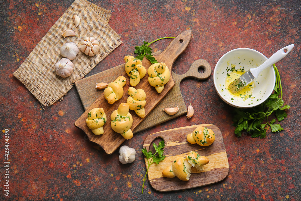 Fototapeta premium Boards with tasty garlic buns on grunge background
