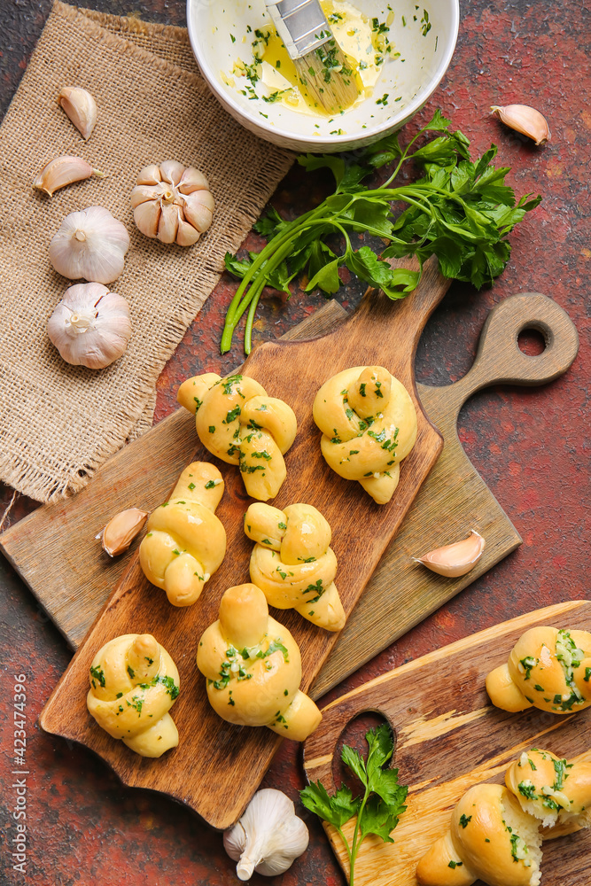 Fototapeta premium Boards with tasty garlic buns on grunge background