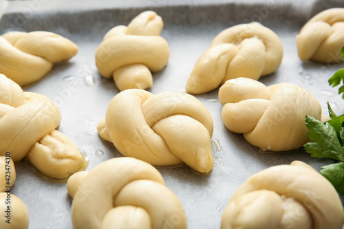 Baking sheet with uncooked garlic buns, closeup