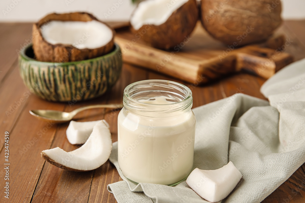 Jar of tasty coconut yogurt on wooden background Jar of tasty coconut yogurt on wooden background