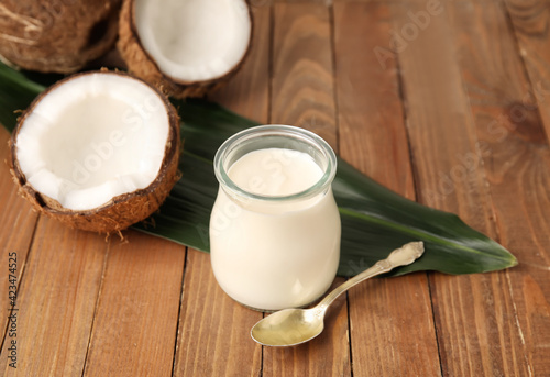 Bilde på lerret Jar of tasty coconut yogurt on wooden background