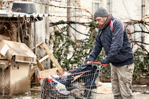Poor homeless man with donations outdoors on winter day