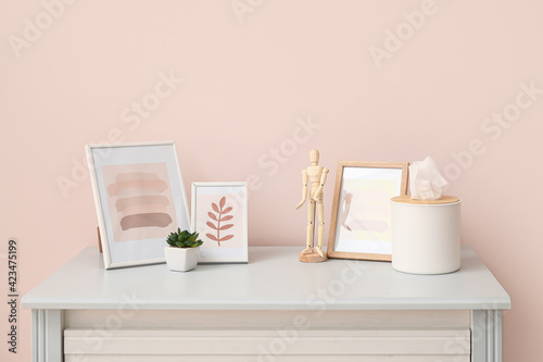 Stylish decor on table near color wall © Pixel-Shot