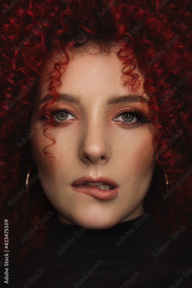 White European girl with afro curls, beautiful casual makeup. Large portrait of a girl with red hair White European girl with afro curls, beautiful casual makeup. Large portrait of a girl with red hair
