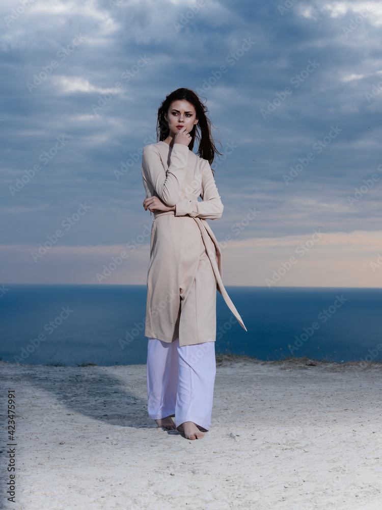 woman in light clothes by the ocean and blue sky in the background woman in light clothes by the ocean and blue sky in the background