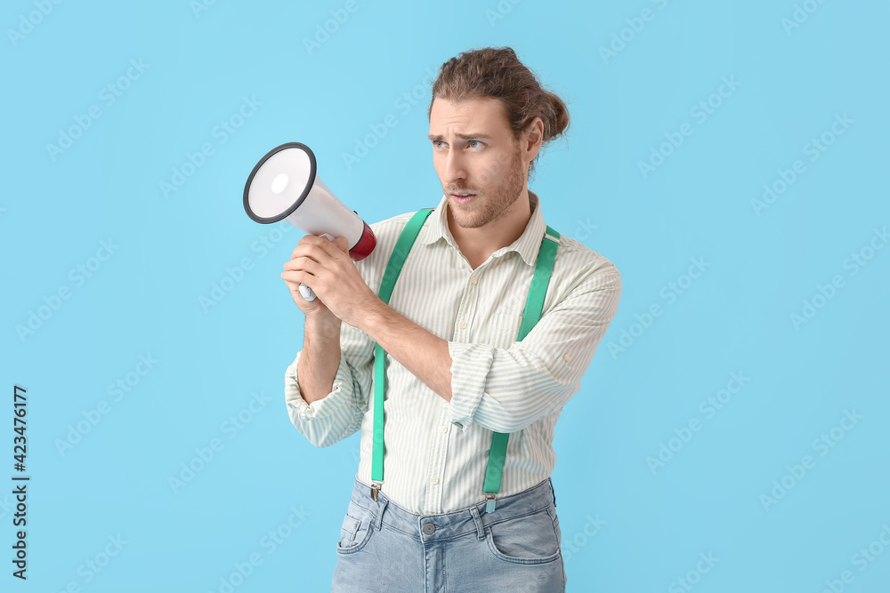 Young man with megaphone on color background Young man with megaphone on color background