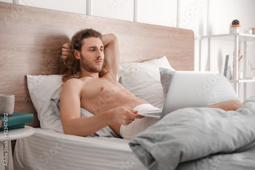 Sexy young man with laptop ...