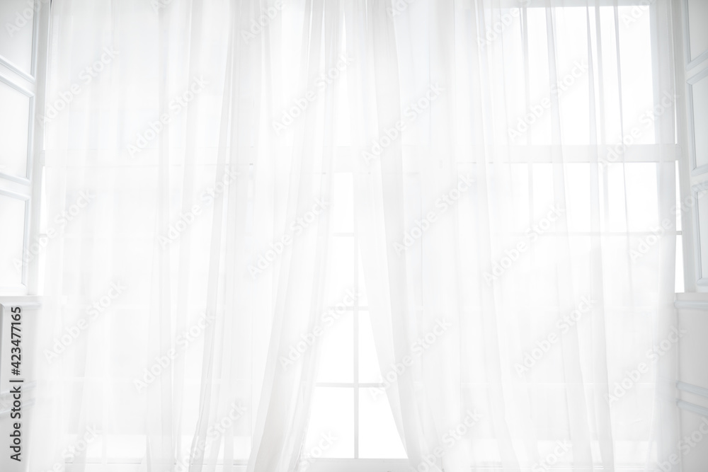 Backlit window with white curtains in empty room Backlit window with white curtains in empty room