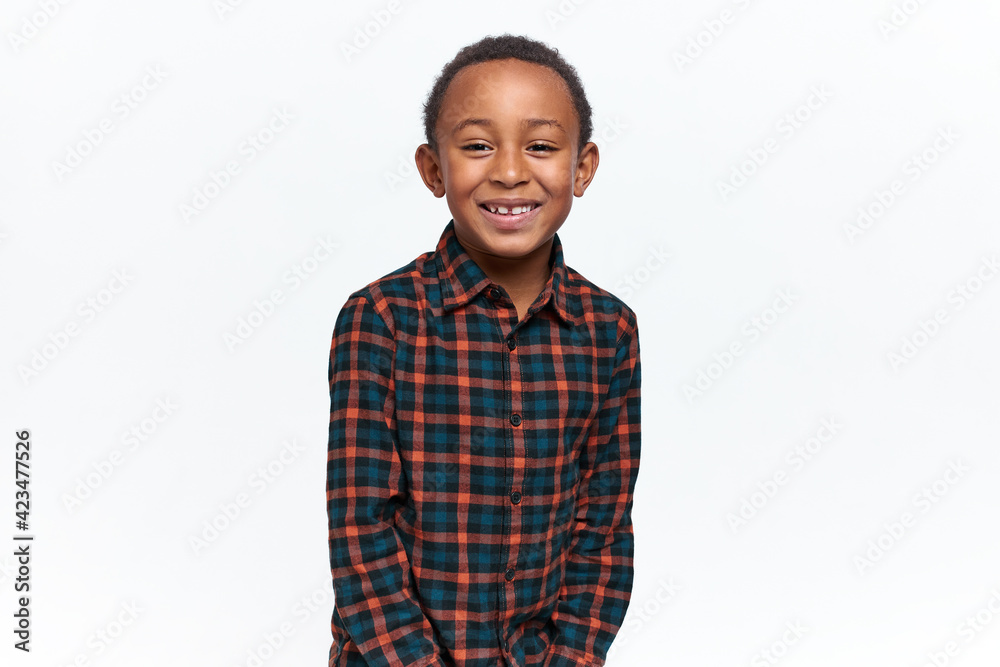 Joy, happiness and positive emotions. Horizontal shot of carefree adorable schoolboy posing isolated with happy facial expression, excited because of excellent marks, having fun, smiling broadly Joy, happiness and positive emotions. Horizontal shot of carefree adorable schoolboy posing isolated with happy facial expression, excited because of excellent marks, having fun, smiling broadly