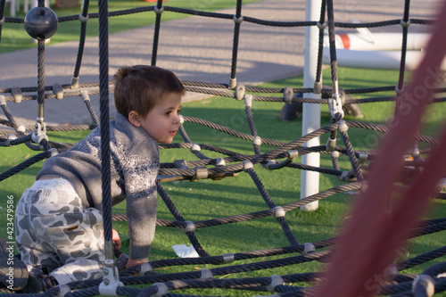 Portrait of a little child boy enjoys playing in a children playground, Outdoor portrait