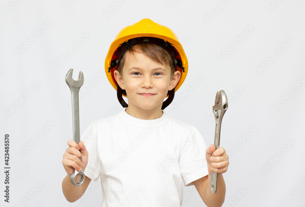 Little Boy using tools at home little builder in the helmet and saw the work of thinking about the future Little Boy using tools at home little builder in the helmet and saw the work of thinking about the future