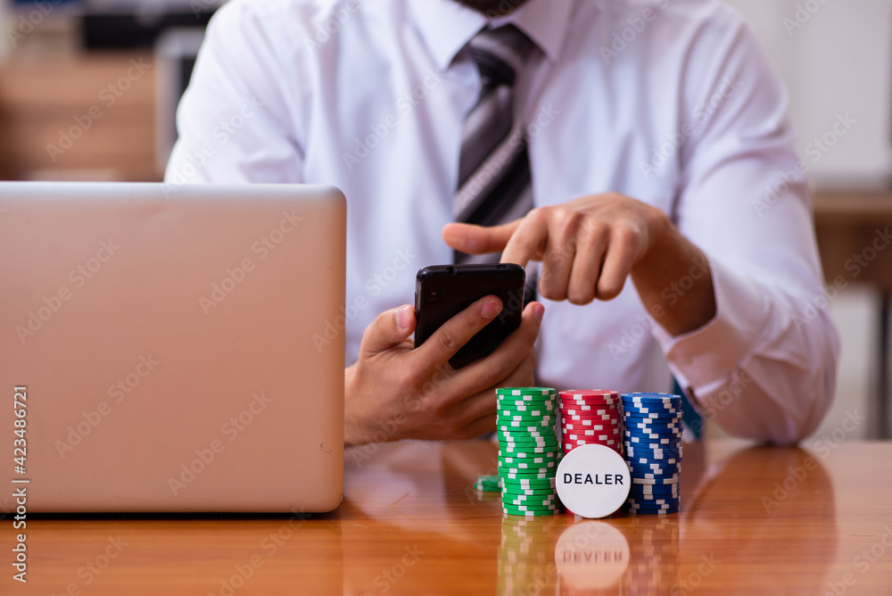 Young male employee in gambling concept Young male employee in gambling concept
