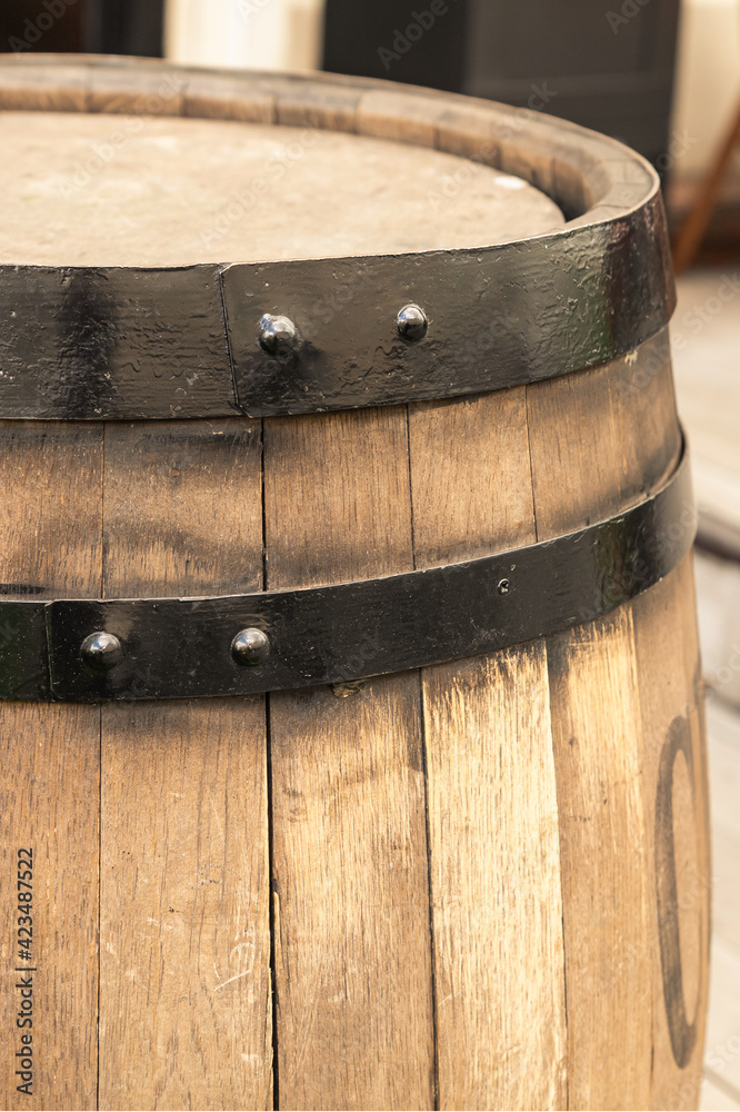 Fototapeta premium light beige oak barrel with a hoop close-up vertically close-up