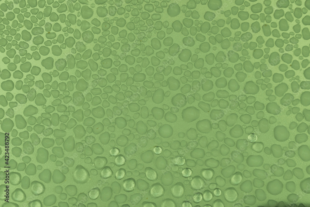 A light green background of frozen water droplets on a rough surface.