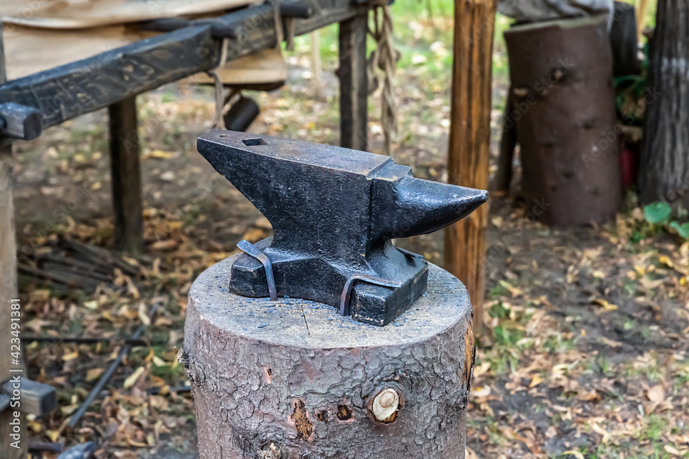 iron black anvil on the stump piece of forge equipment