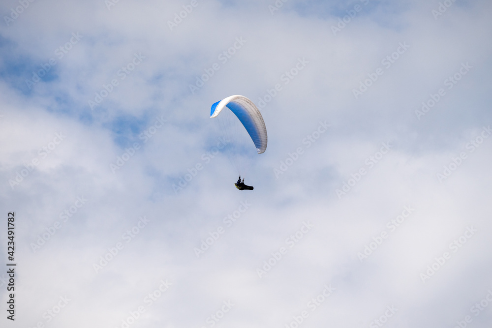 Paraglider flying like a bird in blue cloudy sky. Paraglider flying like a bird in blue cloudy sky.