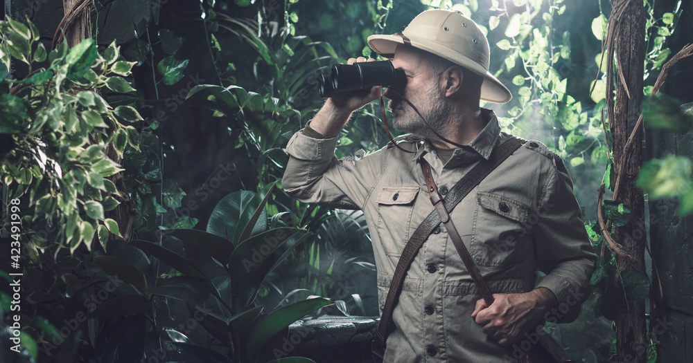 Explorer with binoculars in the jungle