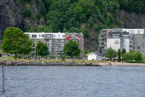 Holmestrand, Norway - June 13 th 2020. A paraglider landing near the beach in Holmestrand. photo