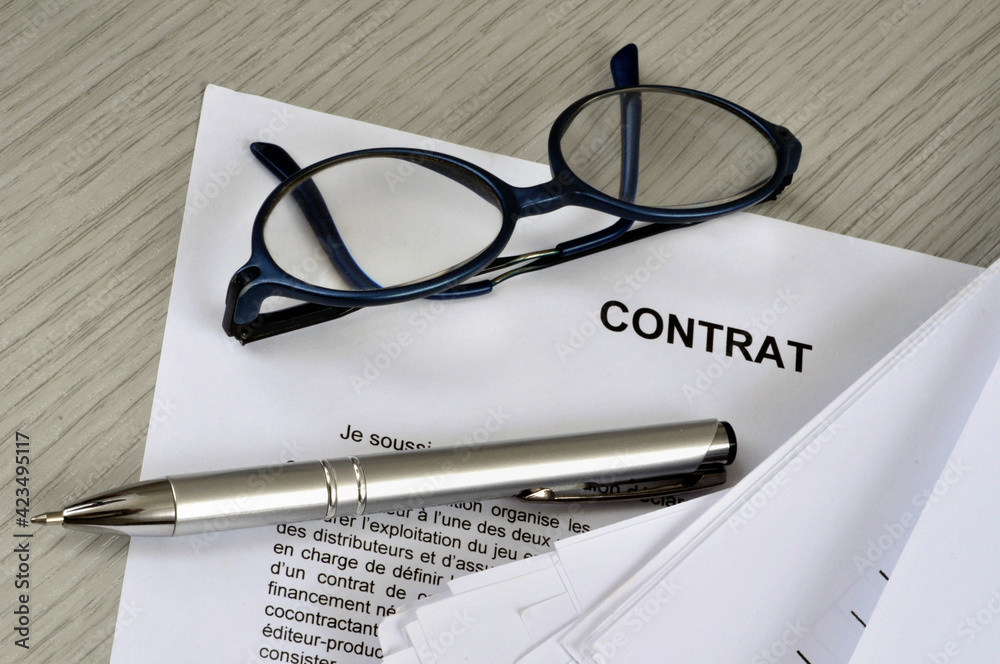 Fototapeta premium Lunettes et stylo posés sur un contrat