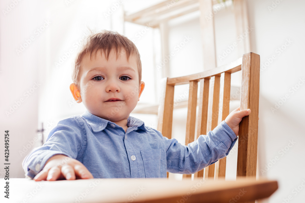 the cute toddler boy is sitting at the table the cute toddler boy is sitting at the table